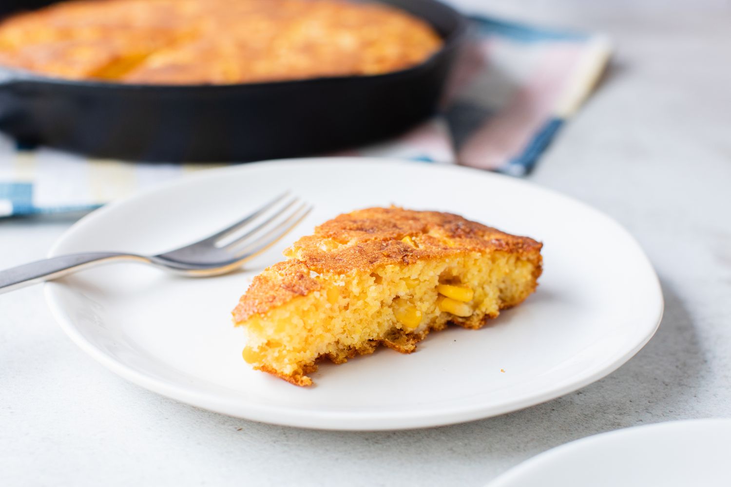 Serving of Cheesy Skillet Cornbread on a Plate with a Fork