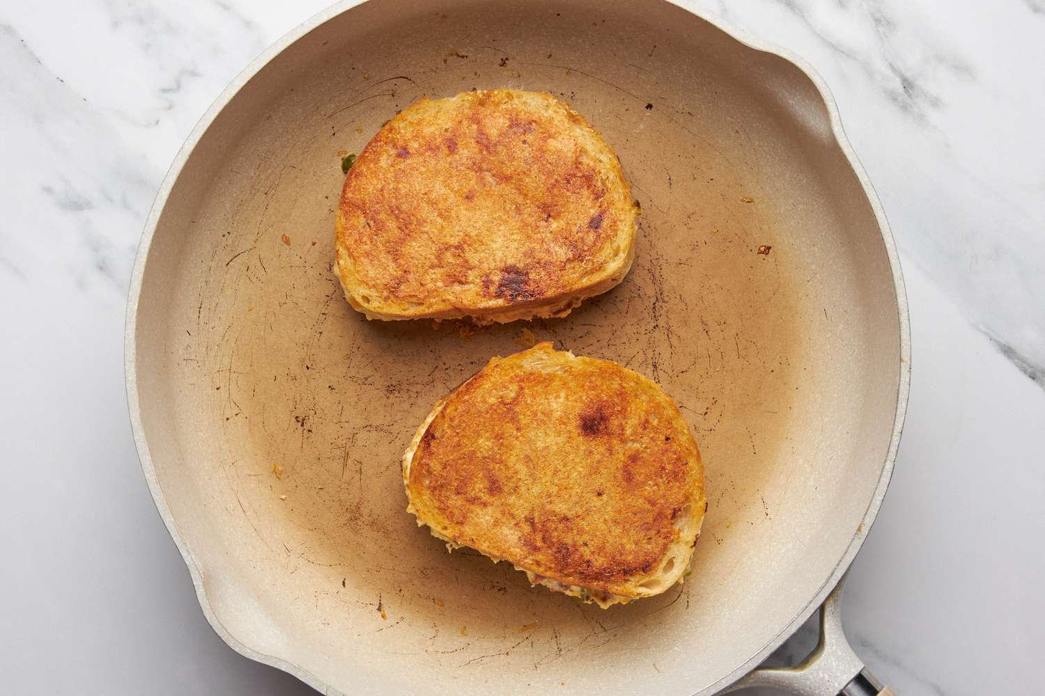 JalapeÃ±o popper grilled cheese toasting on a skillet 