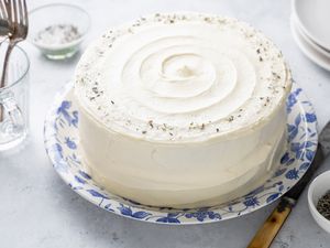Lemon Lavender Cake Surrounded by Forks, a Small Bowl of Lavender, and Plates