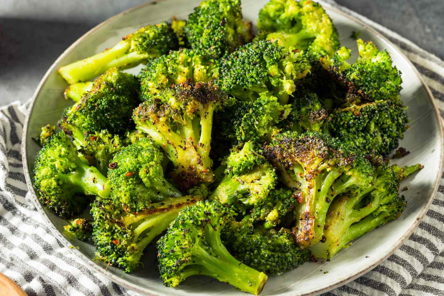 A plate of cooked broccoli seasoned with spices