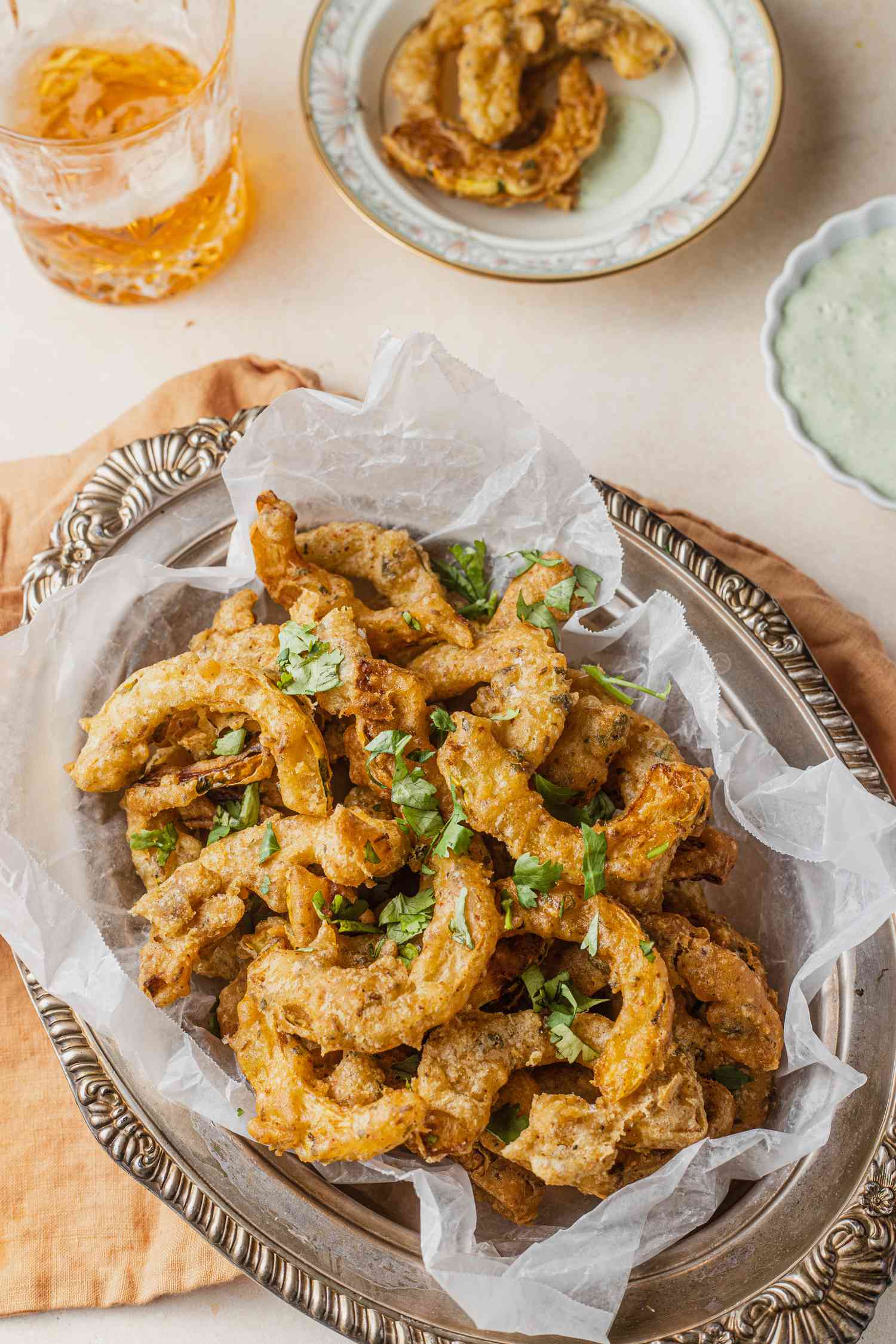 Delicata Squash Pakoras on a Platter, and in the Background, a Small Bowl with a Couple of Pieces and Another Bowl with Chutney