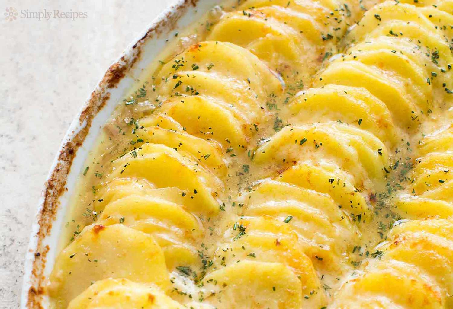 A close-up of scalloped potatoes in a baking dish, ready to serve.