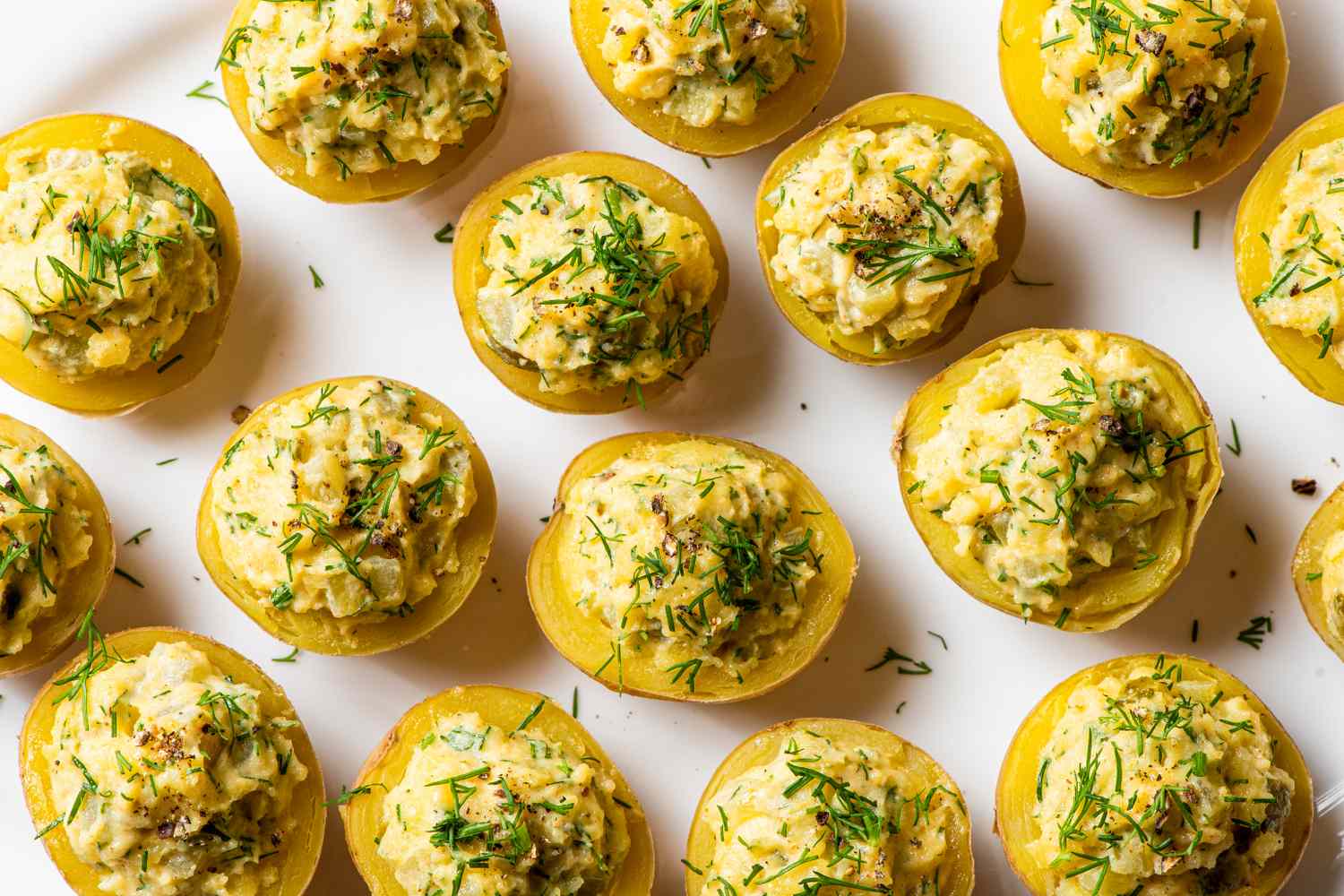 Halved potatoes with a creamy filling and garnished with herbs