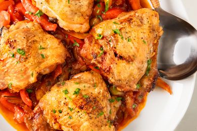 Roasted chicken thighs served atop a vibrant peperonata of sauted peppers and onions