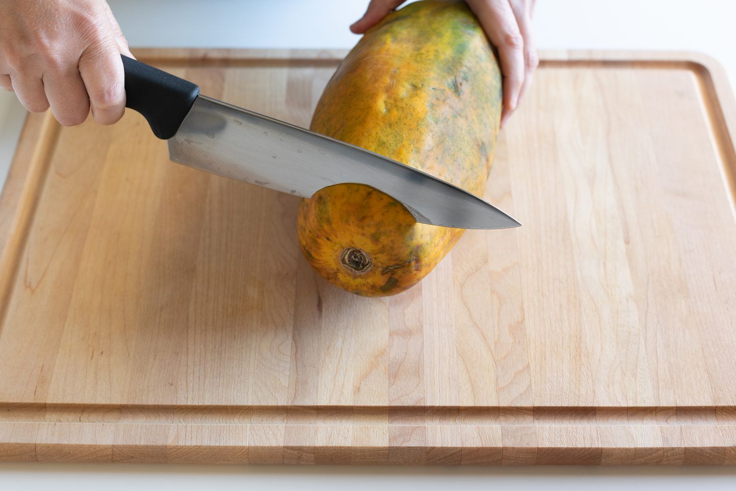 Trimming the ends off a papaya