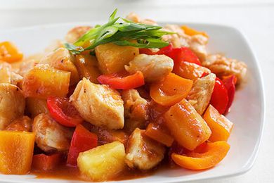 Sweet Sour Chicken on a white plate topped with green onions