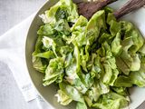 Bowl of Green Salad with Fresh Herbs and Red Wine Vinaigrette with Serving Utensils