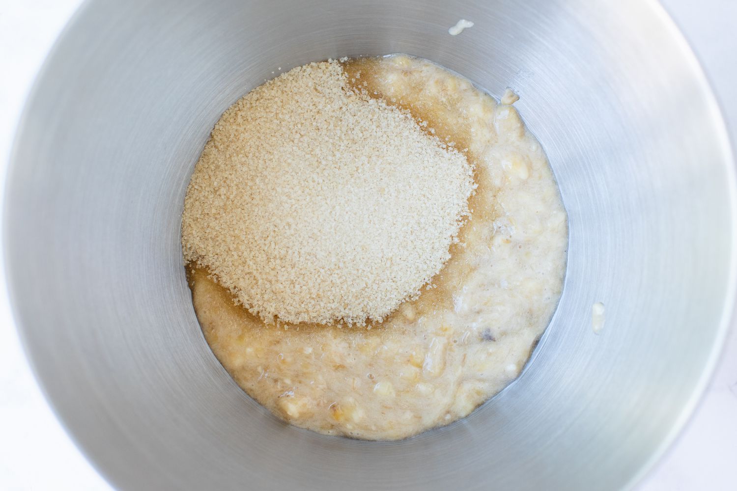 Sugar and bananas in a bowl to make a Banana Nut Muffin recipe