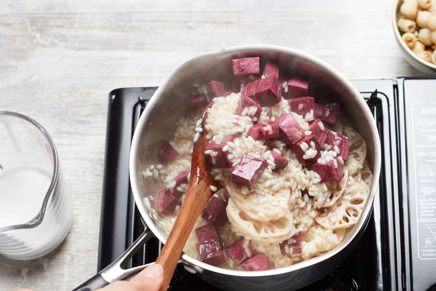 Stirring a pot of easy coconut rice pudding with lotus and sweet potato 