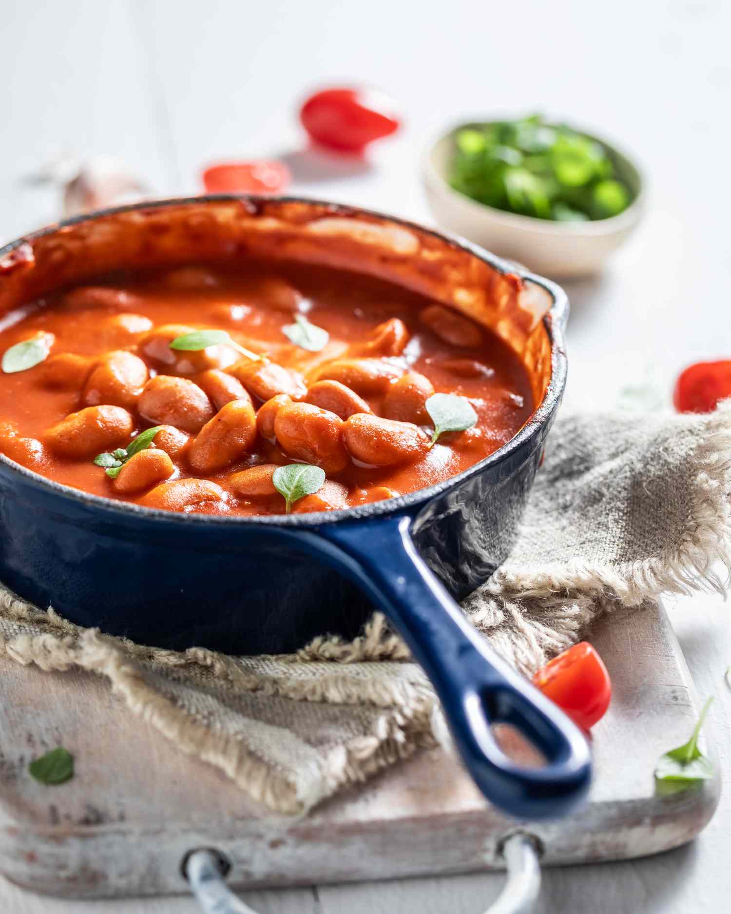 Baked beans in a blue skillet on a wooden surface