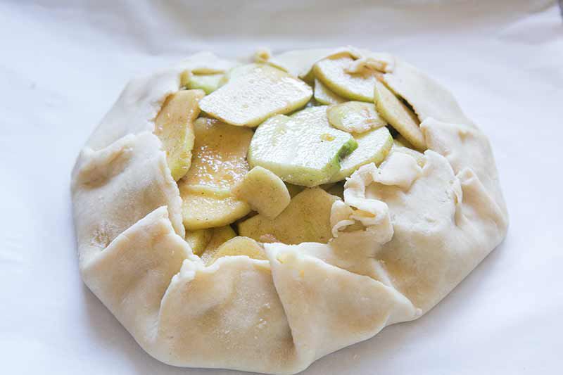 wrapping apples up in dough for apple crostata