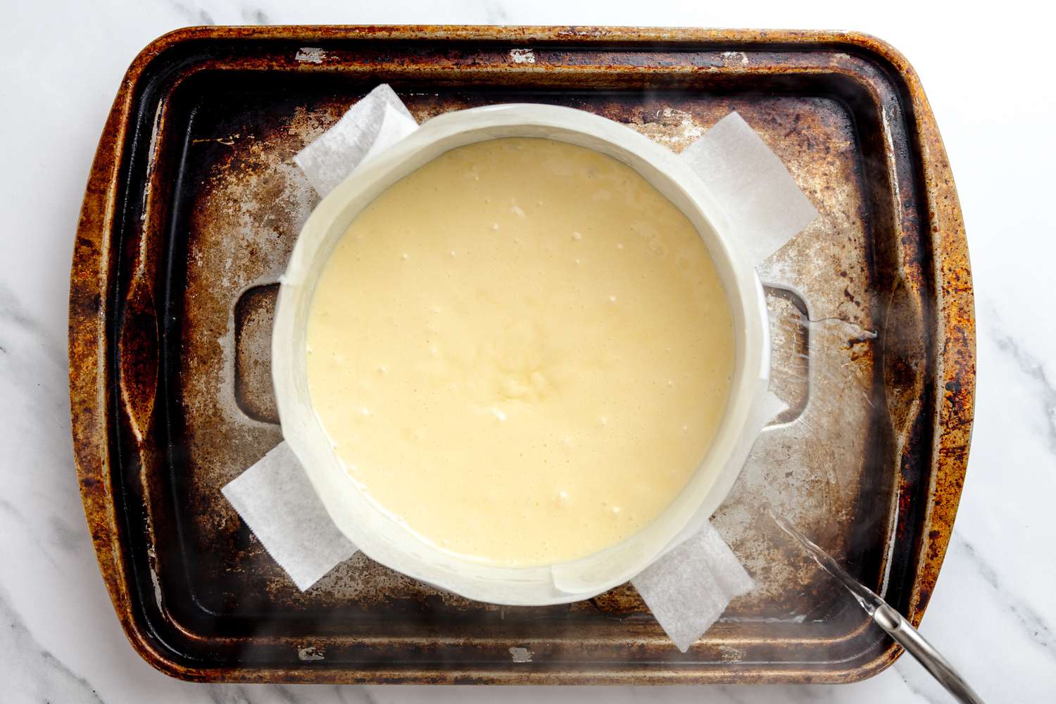 Hot Water Added to a Roasting Pan With the Cake Pan on It 