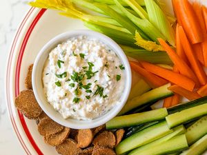 Spiced Cottage Cheese Dip in a bowl with veggies/melba toast around it