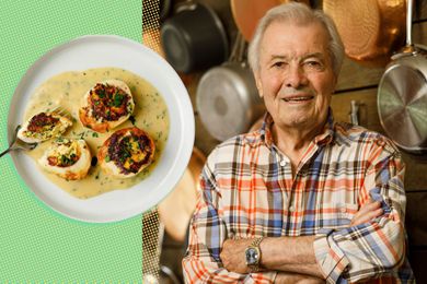 Jacques Pépin next to a plate of halved hard-boiled eggs that appear to be browned on top and are sitting in a little puddle of herb-flecked sauce on a plate