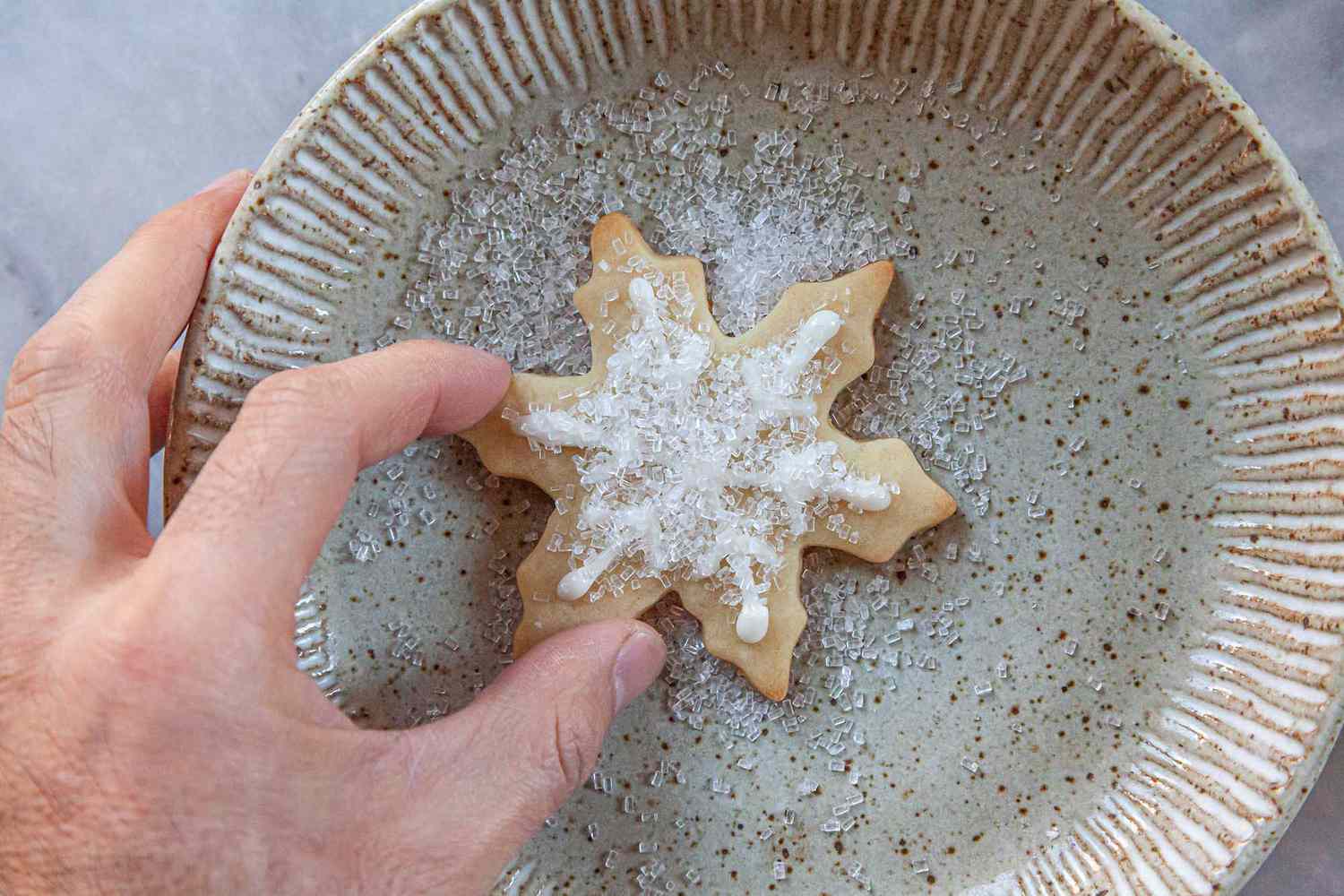 Sparkling sugar added to a snowflake sugar cookie decorated with Royal icing for sugar cookies.