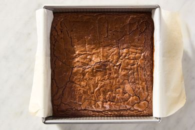Freshly baked pan of brownies on a parchmentlined square baking dish
