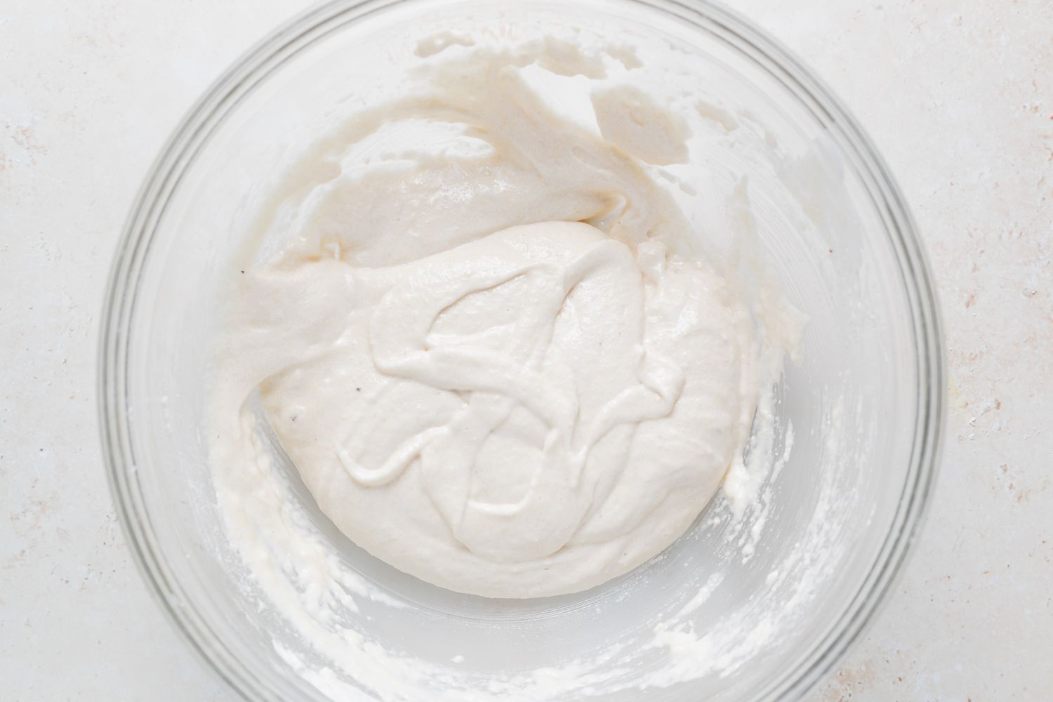 The batter for French macarons with peppermint white chocolate filling in a glass bowl.