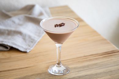 A chocolate martini in a martini glass, garnished with chocolate shavings