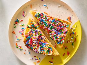 Two halves of toast covered in colorful sprinkles on a patterned plate