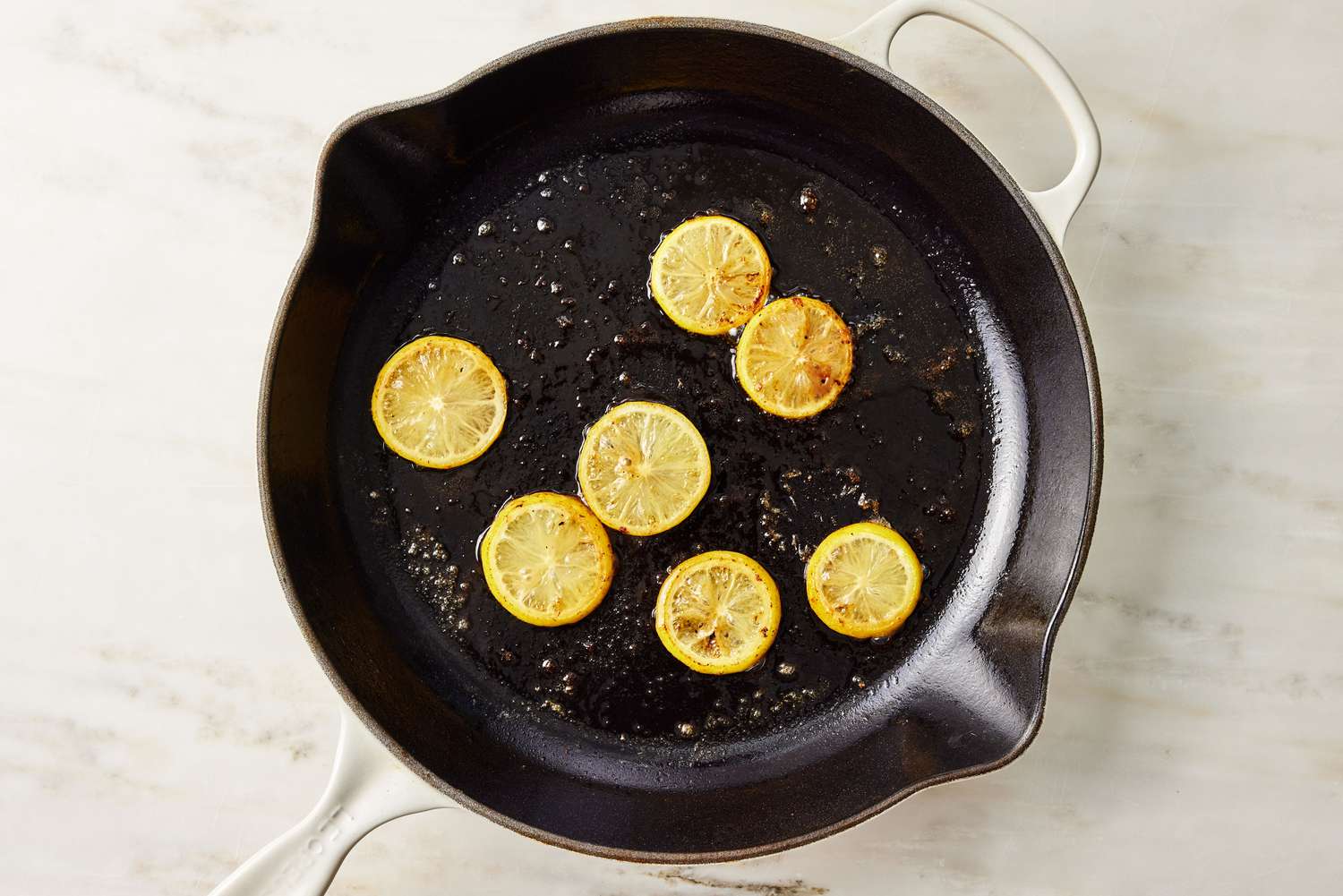 sliced lemons in skillet with melted butter for Chicken Francese recipe
