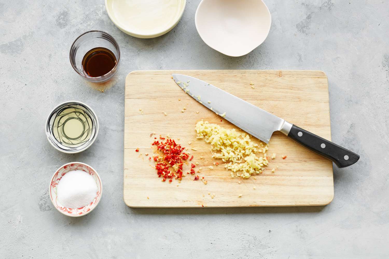 Minced Ginger and Pepper on Cutting Board Next to Other Ingredients for Chào Gá (Vietnamese Rice Porridge) Dipping Sauce