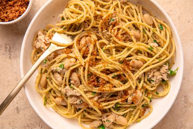 Pasta with tuna, white beans, herbs, and breadcrumbs in a bowl, fork resting on the side.