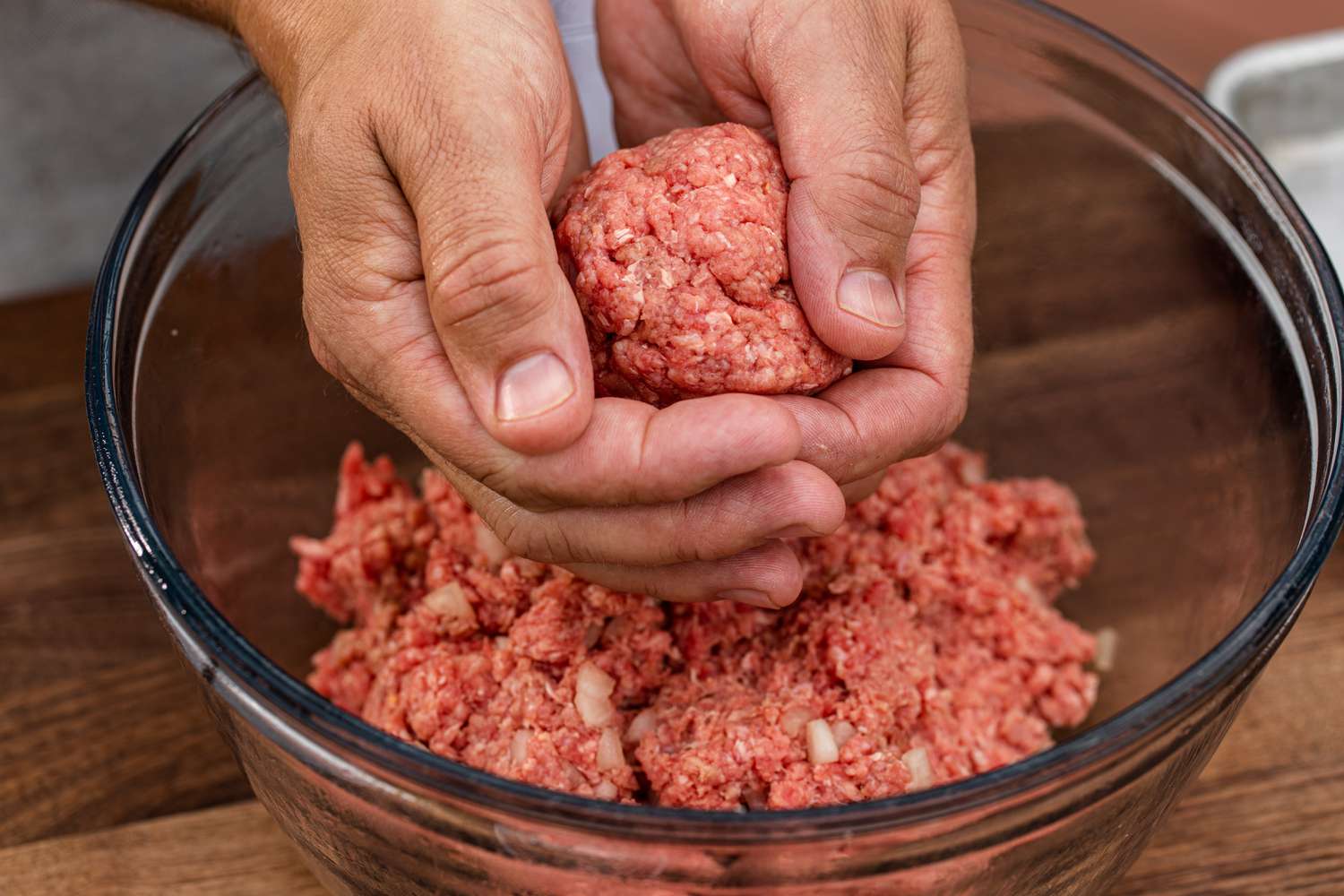 Forming balls of ground beef to make a classic bacon cheeseburger