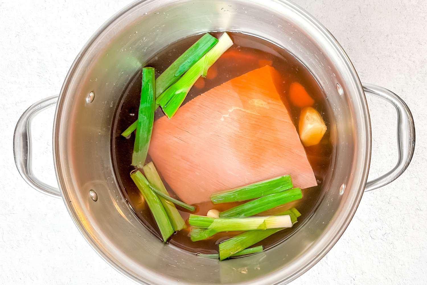 Beef Brisket in a Pot With Broth Ingredients (Green Onions, Garlic, Water, and Soy Sauce) for Korean Cold Noodle Soup Recipe