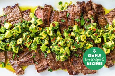 Grilled steak slices topped with avocado chimichurri and garnished with herbs