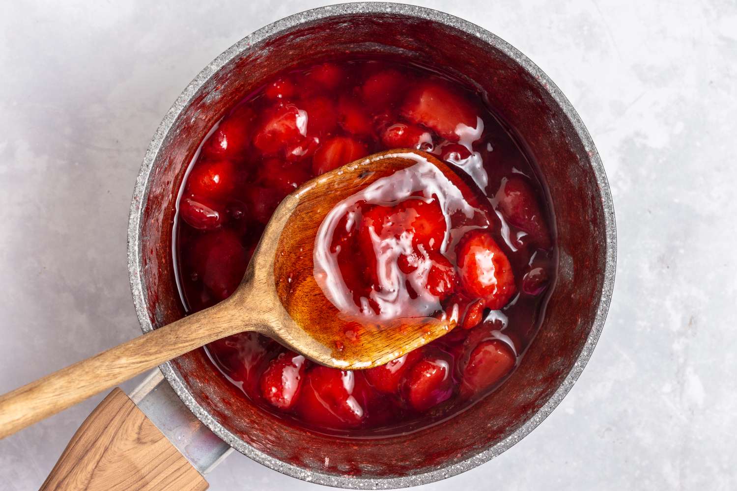 Strawberry sauce in a pan for an easy no bake cheesecake recipe.