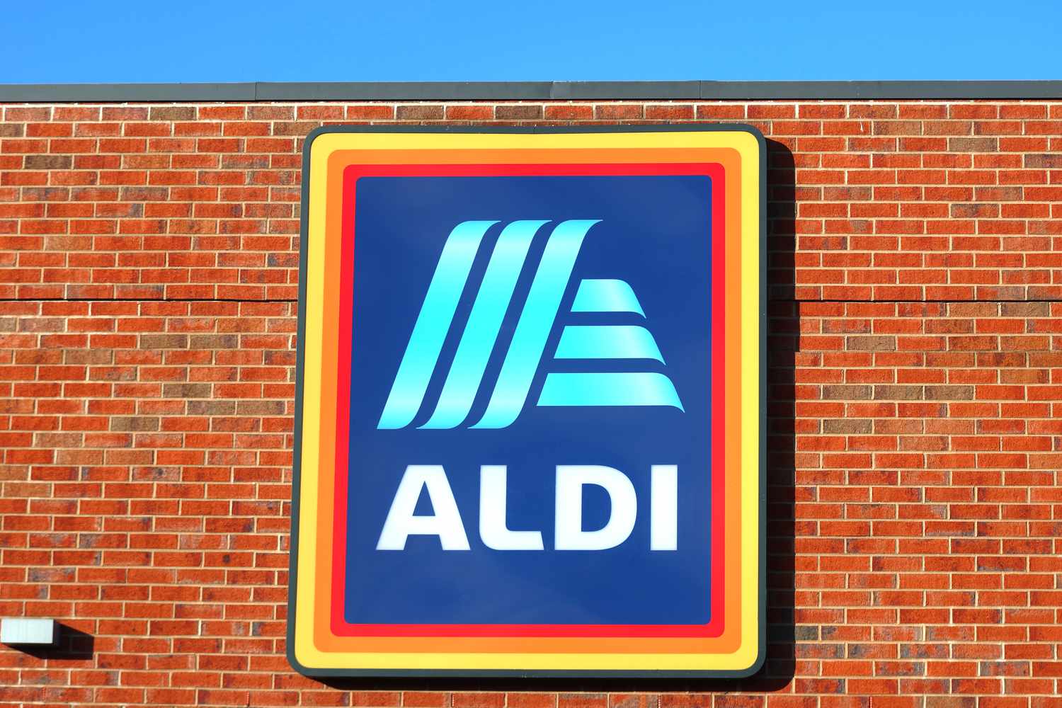 A building with the ALDI logo and sign displayed prominently on a brick wall