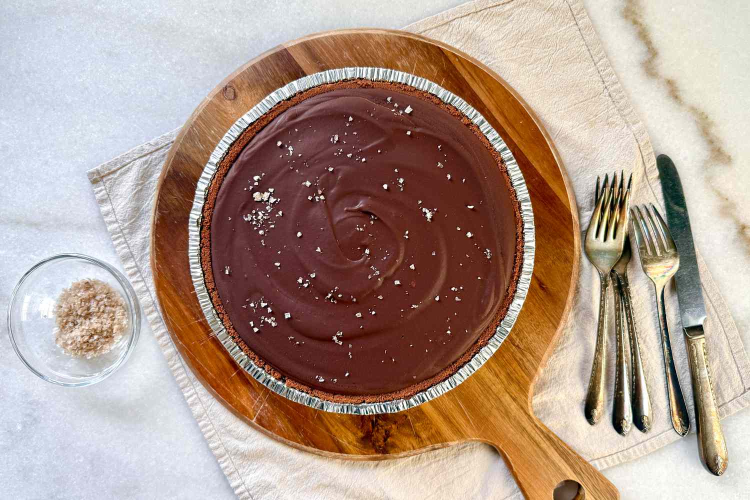A chocolate tart on a wooden serving board