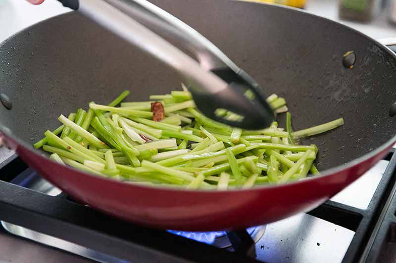 stir frying celery in a wok