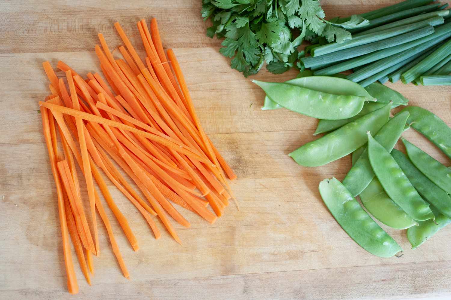 Carrots cut into thin strips to make a vegetarian rice noodle salad.