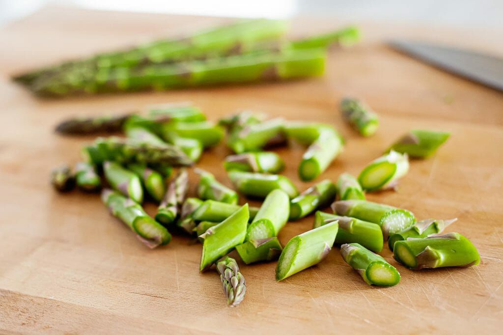 chopped asparagus on a cutting board