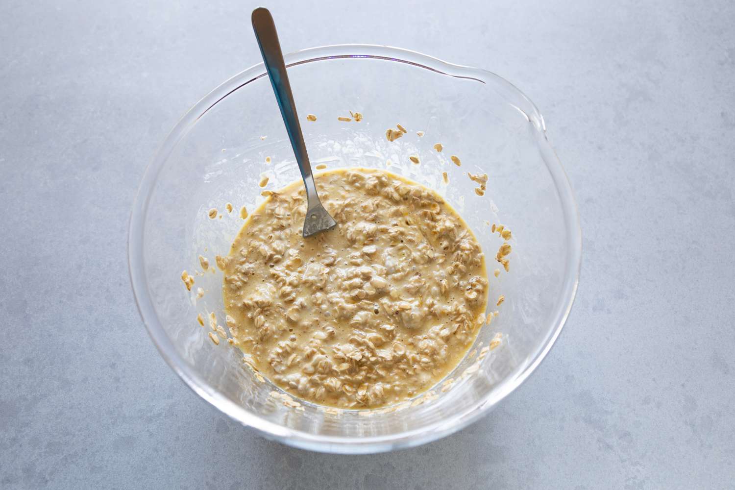 Oatmeal mixed in a glass bowl to make Mixed Berry Baked Oatmeal.