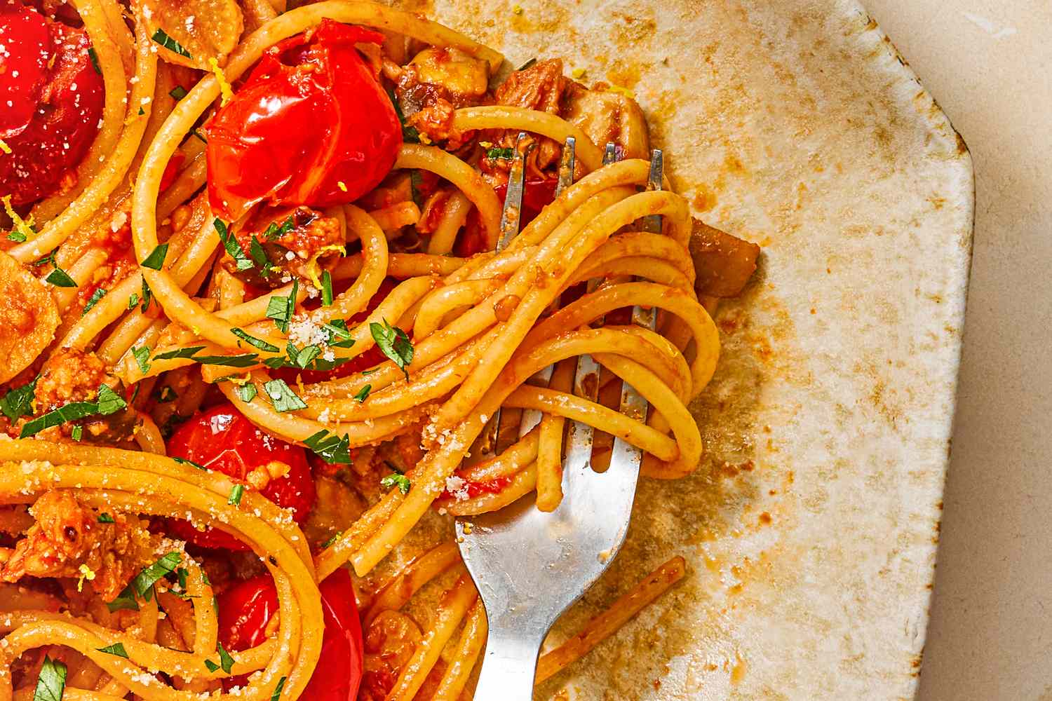 Spaghetti served with cherry tomatoes and herbs a fork is placed on the plate