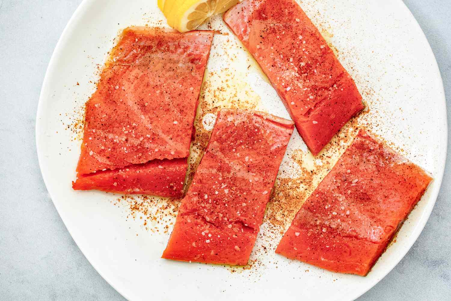Seasoned Salmon on a Plate with Lemon Slices for Air Fryer Salmon Recipe