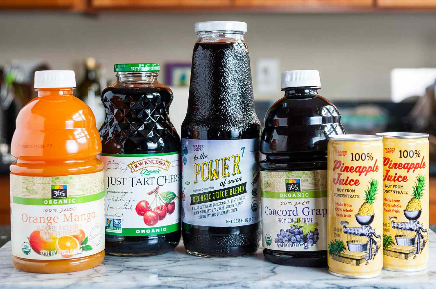 Several bottles of store-bought juice on a counter