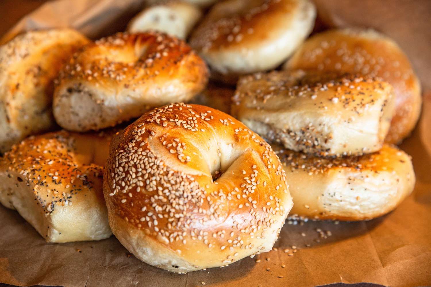 Assorted bagels topped with sesame and seeds on a brown surface