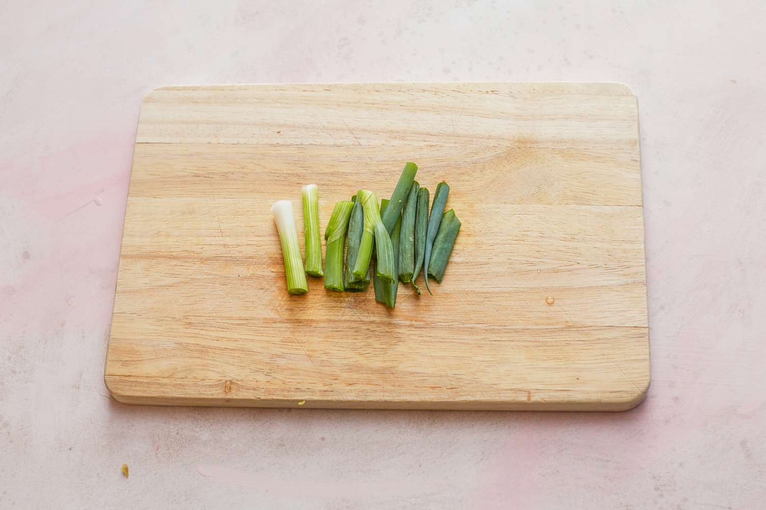 Chopping scallions with a chef's knife to make whole steamed black sea bass