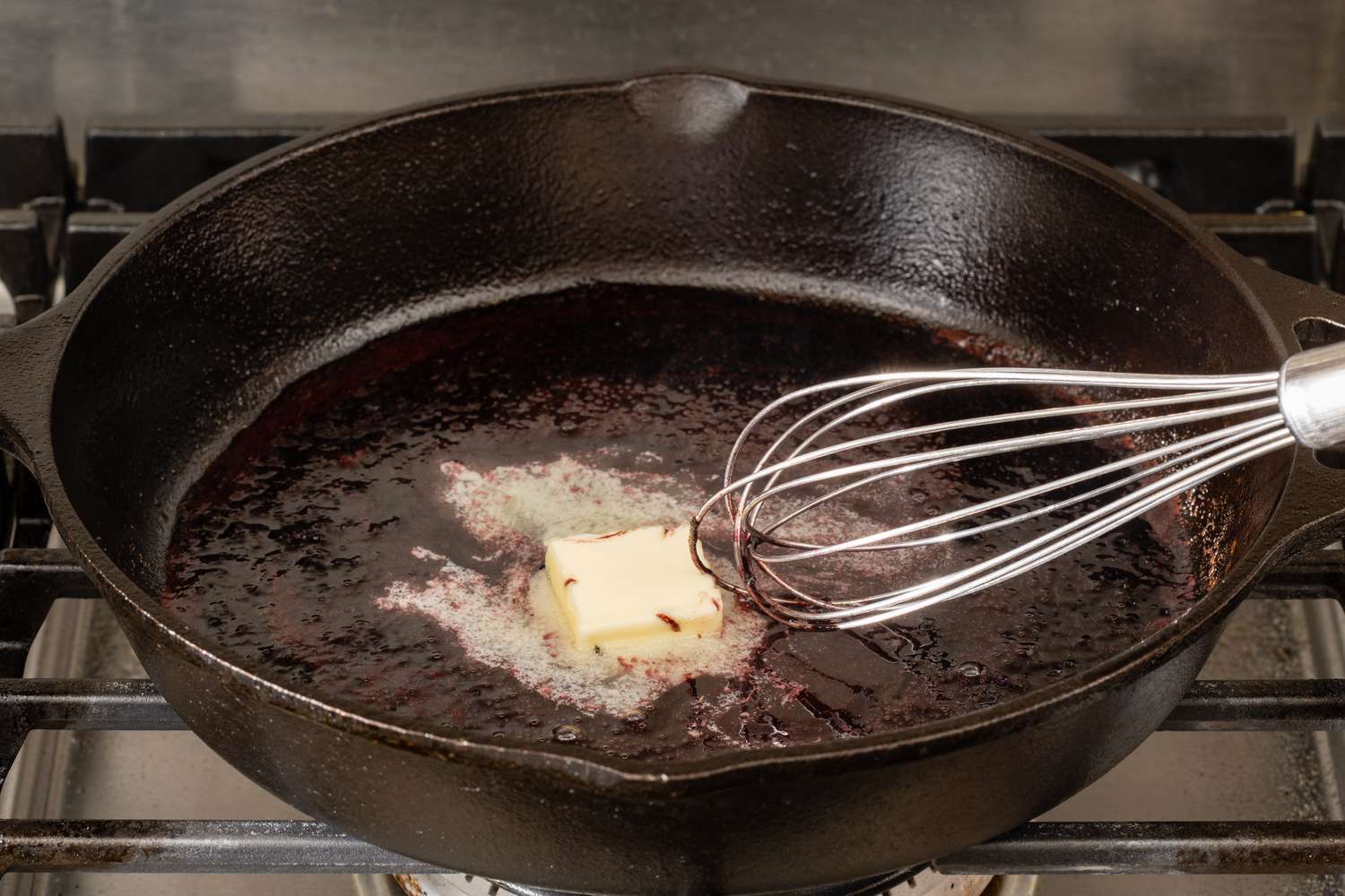 Whisking butter into a red wine reduction for a sauce for filet mignon