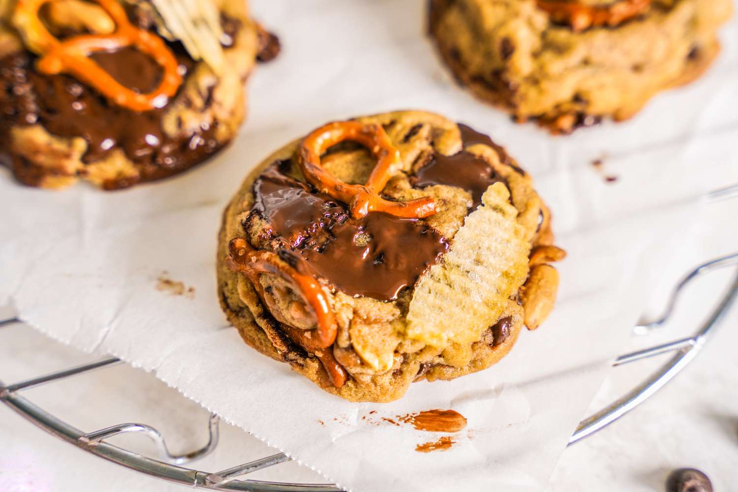 Kitchen Sink Cookies on a Piece of Crumpled Parchment Paper on a Cooling Rack