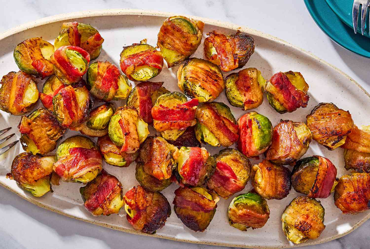 Bacon wrapped Brussels sprouts on a large oval serving plate