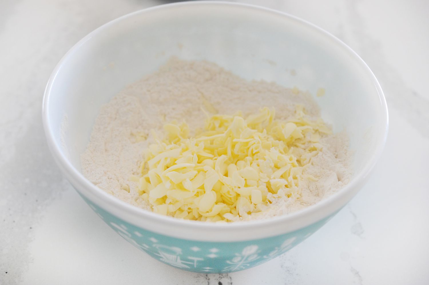 Dry ingredients with grated butter in a bowl to make The Best English Scones.