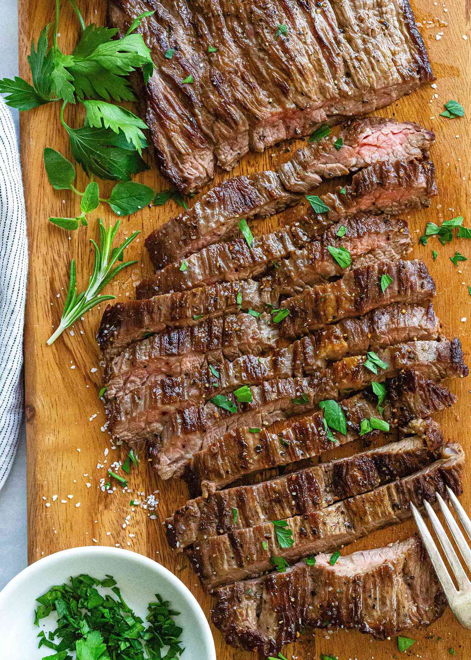 How to Cook Skirt Steak in a Pan - sliced steak with herbs on top