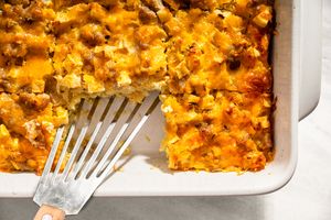 Baked casserole dish with a section removed exposing the interior texture with visible cheese sausage and apple pieces
