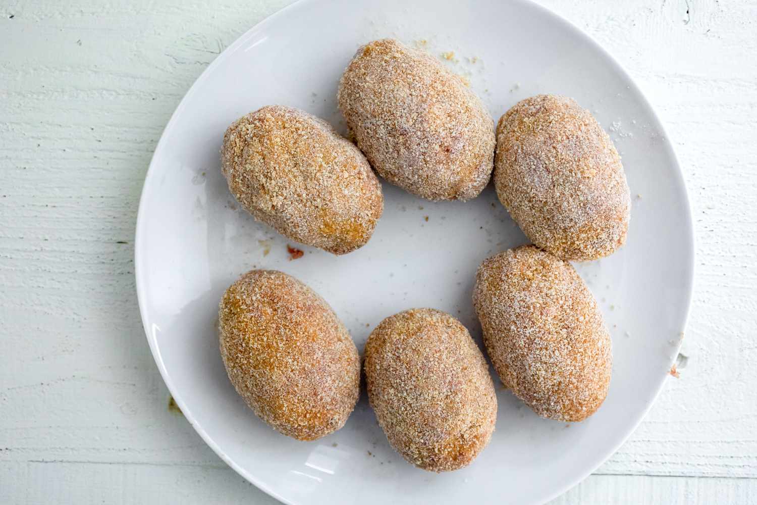 Breaded Scotch eggs on a plate. 
