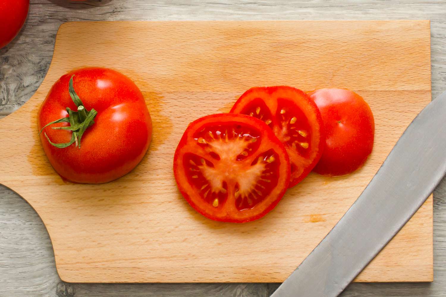 tomato cut into slices on a cutting board
