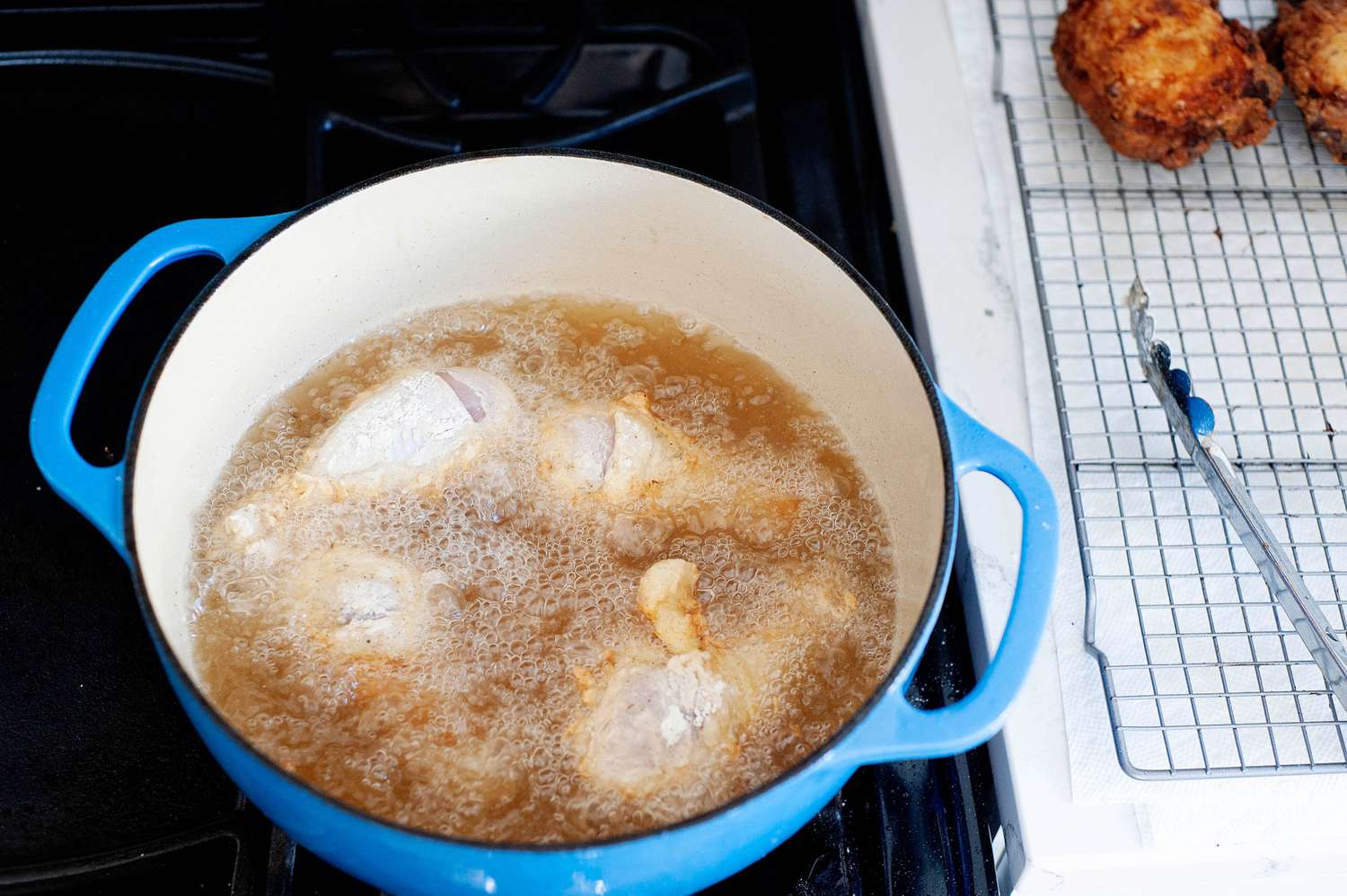 A dutch oven with oil and chicken to show how to fried chicken.